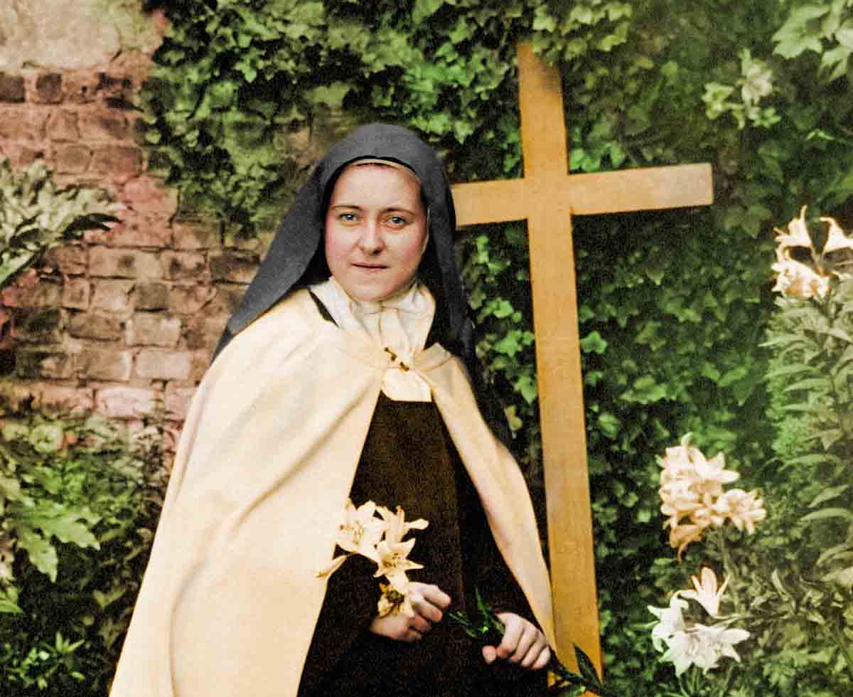 Santa Teresinha com rosas, símbolo das graças e milagres que derrama do Céu sobre os fiéis.